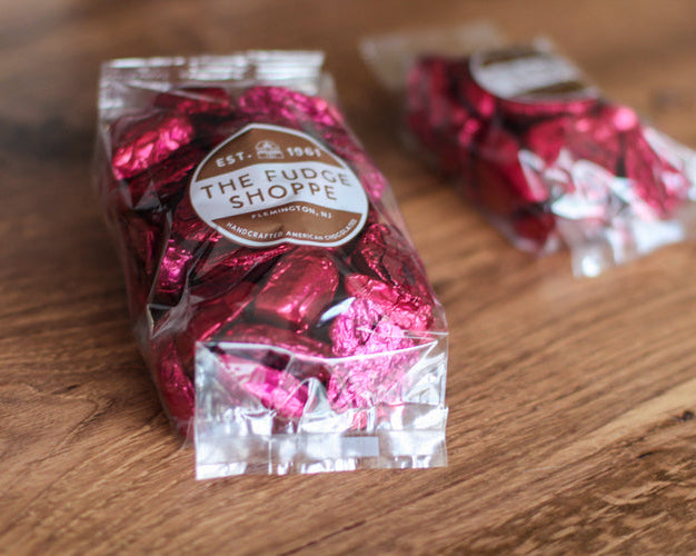 burgundy hearts in clear packaging with a visible brand label on a wooden surface.
