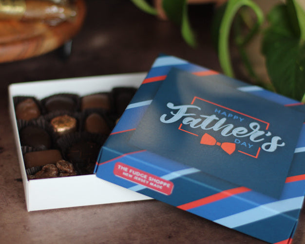 Box of chocolates with a 'Happy Father's Day' card on a wooden surface