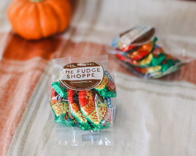 milk chocolatte foiled turkeys checkered fabric background with a pumpkin.