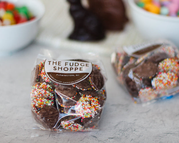 Packaged chocolate nonpareils with spring colored sprinkles on a table