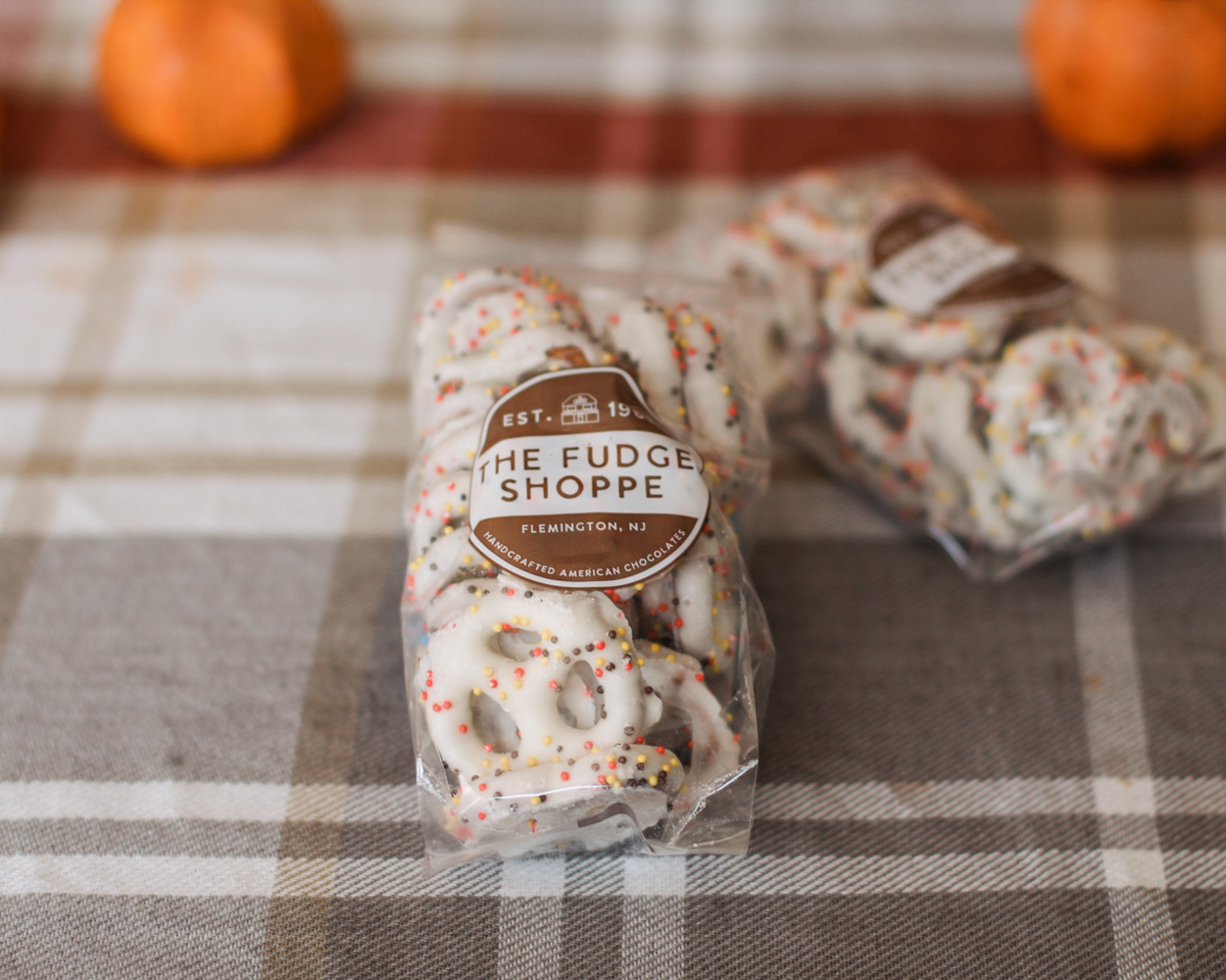 Two clear plastic bags of white pretzels with colorful sprinkles