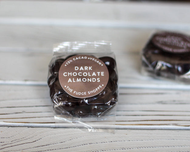 Packaged dark chocolate almonds on a wooden surface