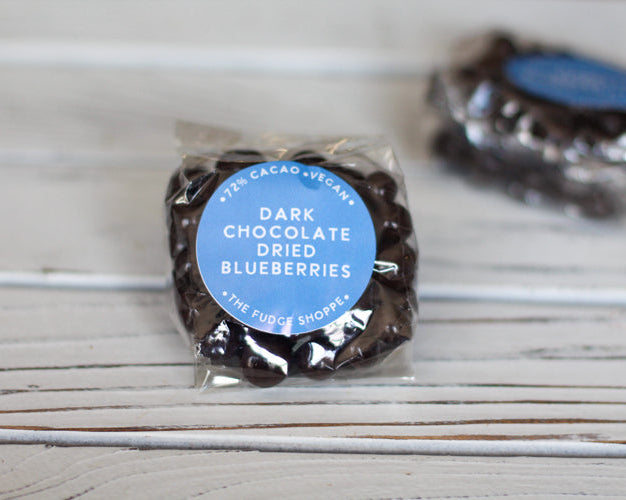 Dark chocolate dried blueberries in a clear package with a blue label on a white background.