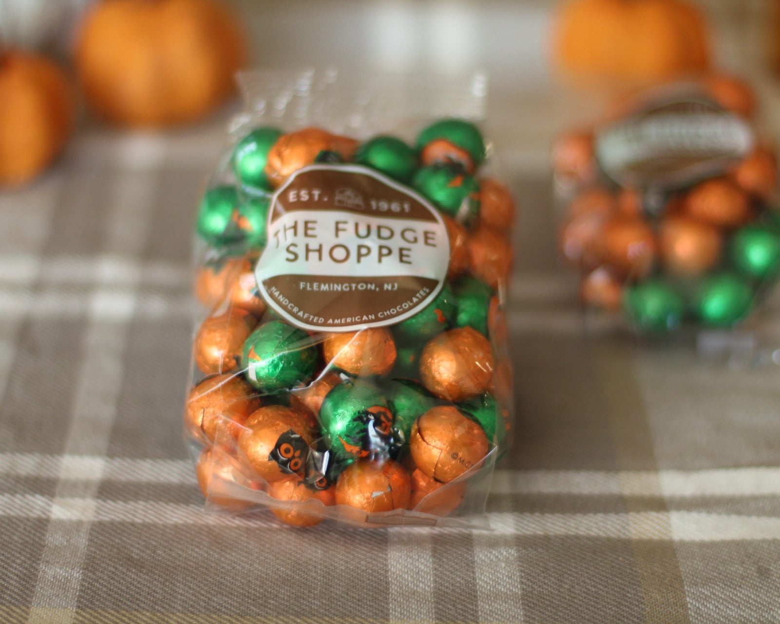 Bag of Halloween chocolate balls on a checkered tablecloth.