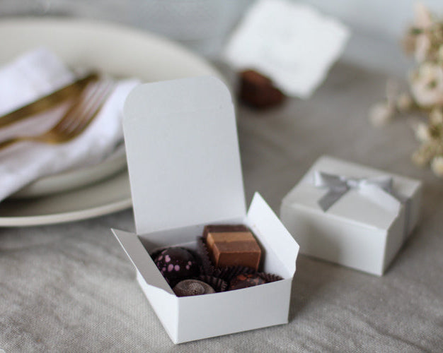 White box with chocolates on a table with a blurred background