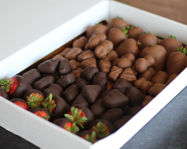A box of assorted chocolate-covered fruits including strawberries, blueberries, and other potential fruits based on the product description.