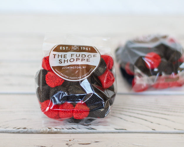 Packaged german raspberries on a light wooden surface.