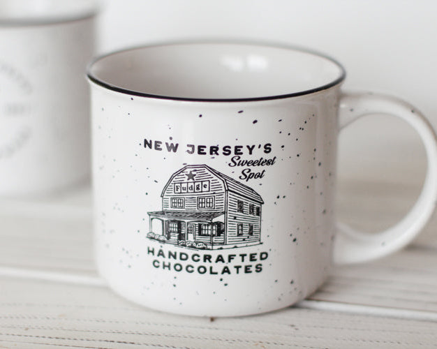 White mug with black text and design on a wooden surface