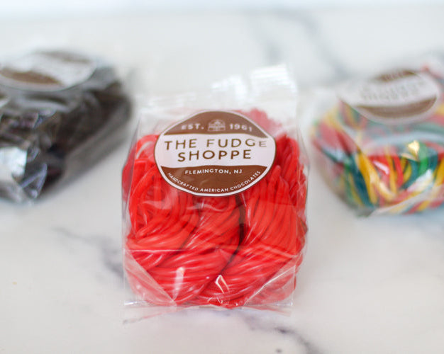 red and colorful licorice shoestring in a bagel on a white background