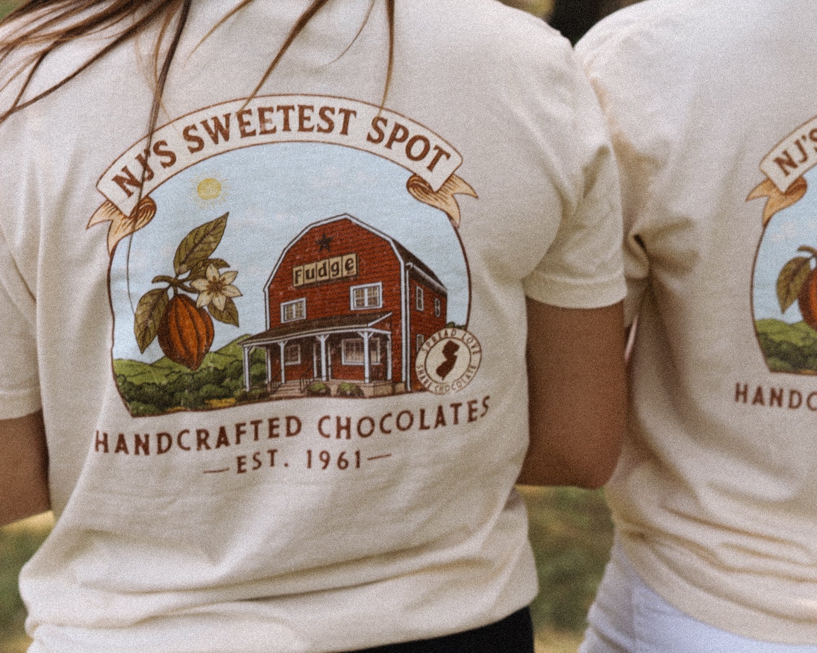Two people wearing t-shirts with a chocolate-themed design and text.