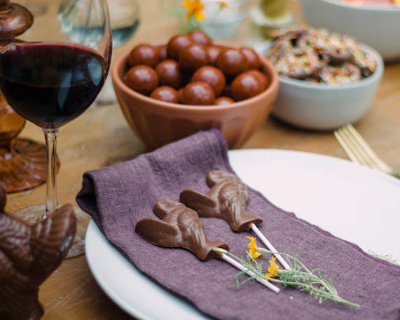 chocolate turkey pop on a thanksgiving table with chocolates around