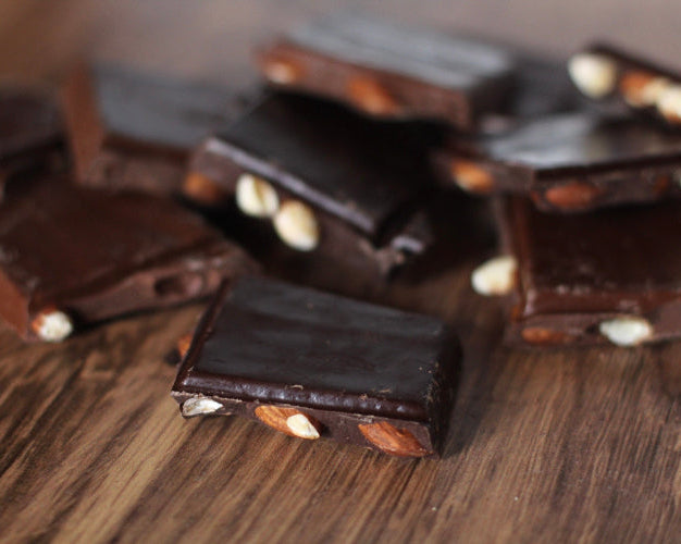 Sugar free chocolate bark with nuts on a wooden surface 